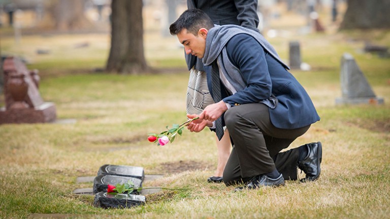 Aram deja flores para su familia en el cementerio