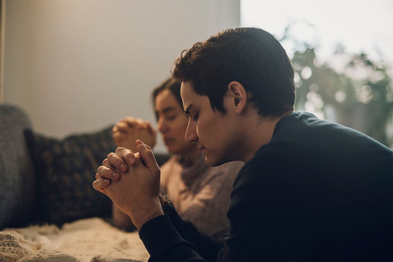 Una pareja se arrodilla para orar juntos a Dios