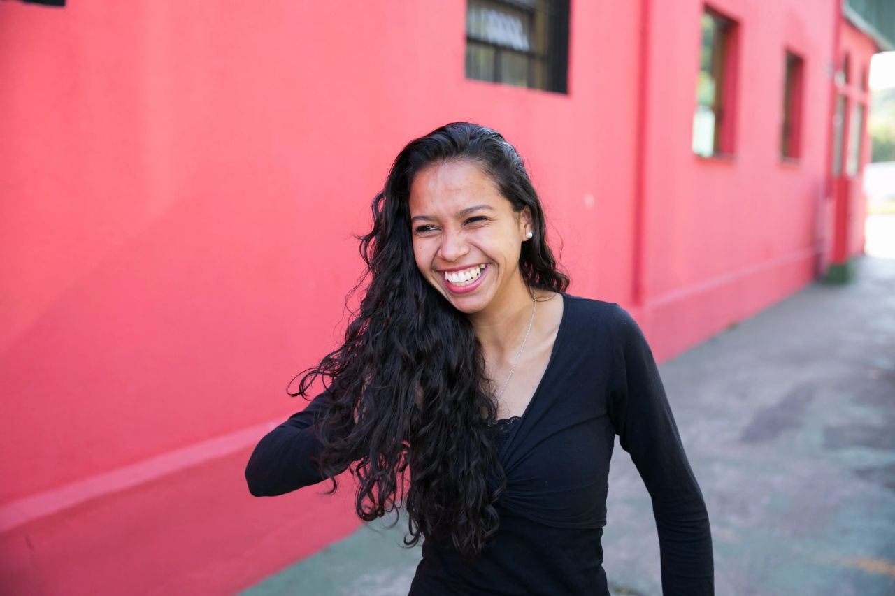 Una mujer sonríe al sentir el amor de Dios en su vida