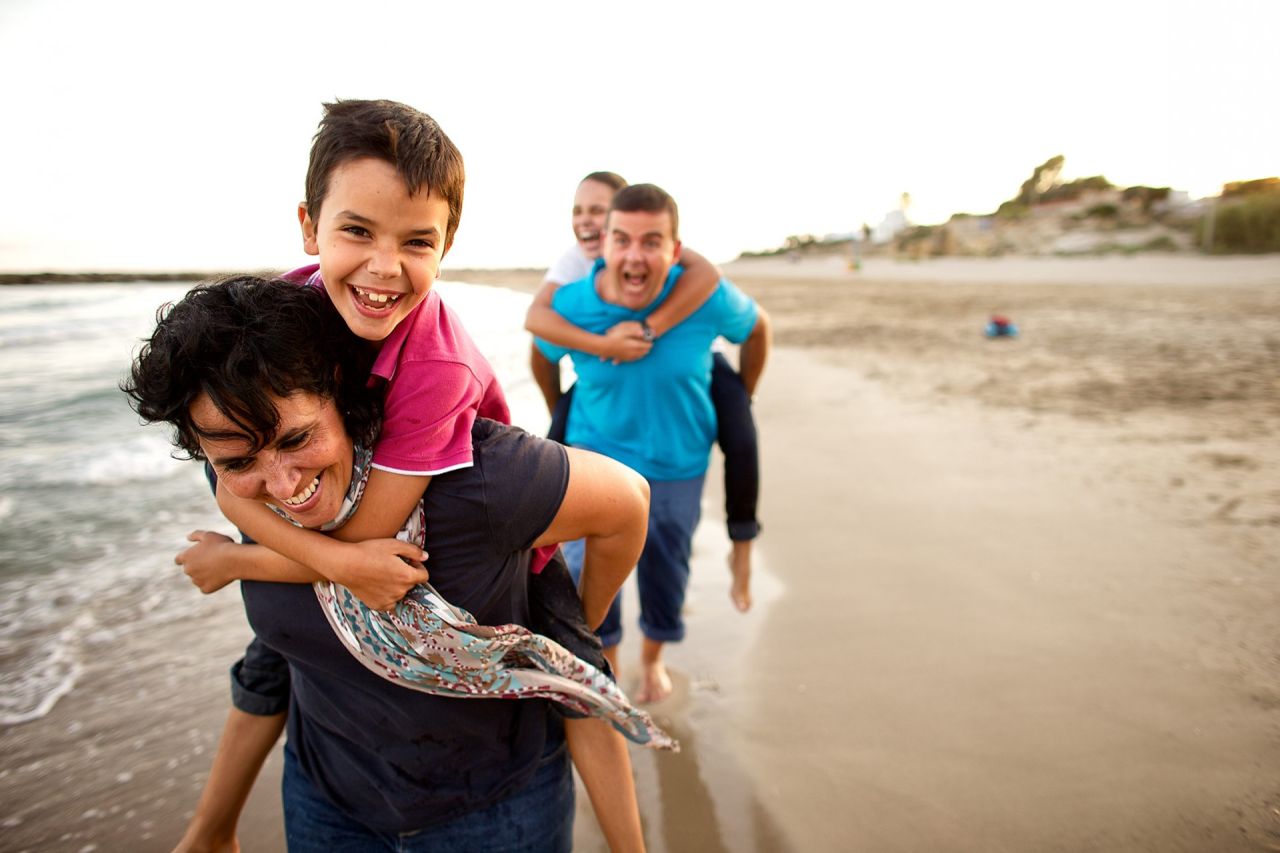 Una familia juega feliz en la playa