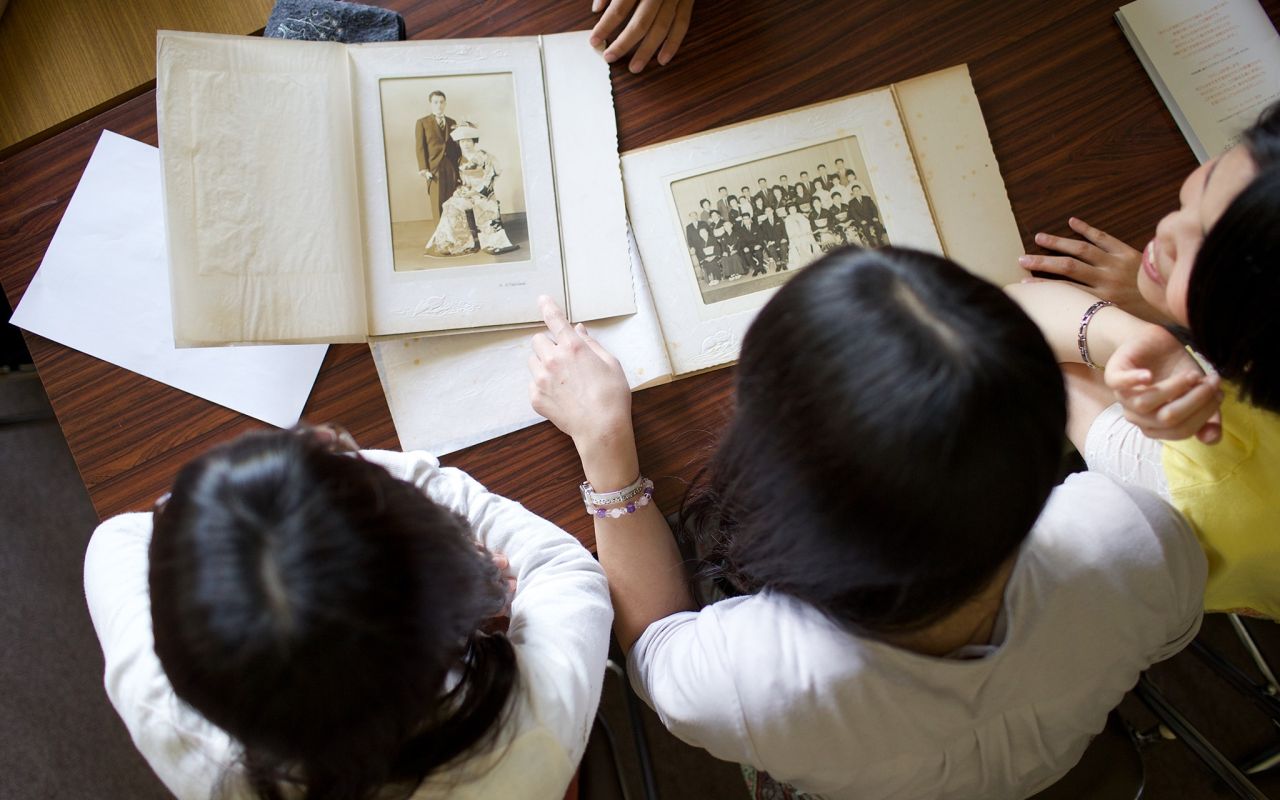 Una familia hace historia familiar junta consultando libros de recuerdos