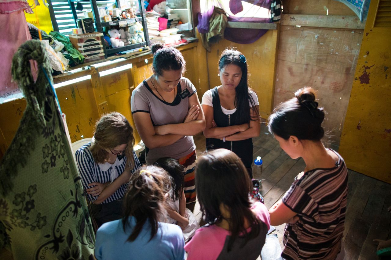 Dos misioneras orando con una familia
