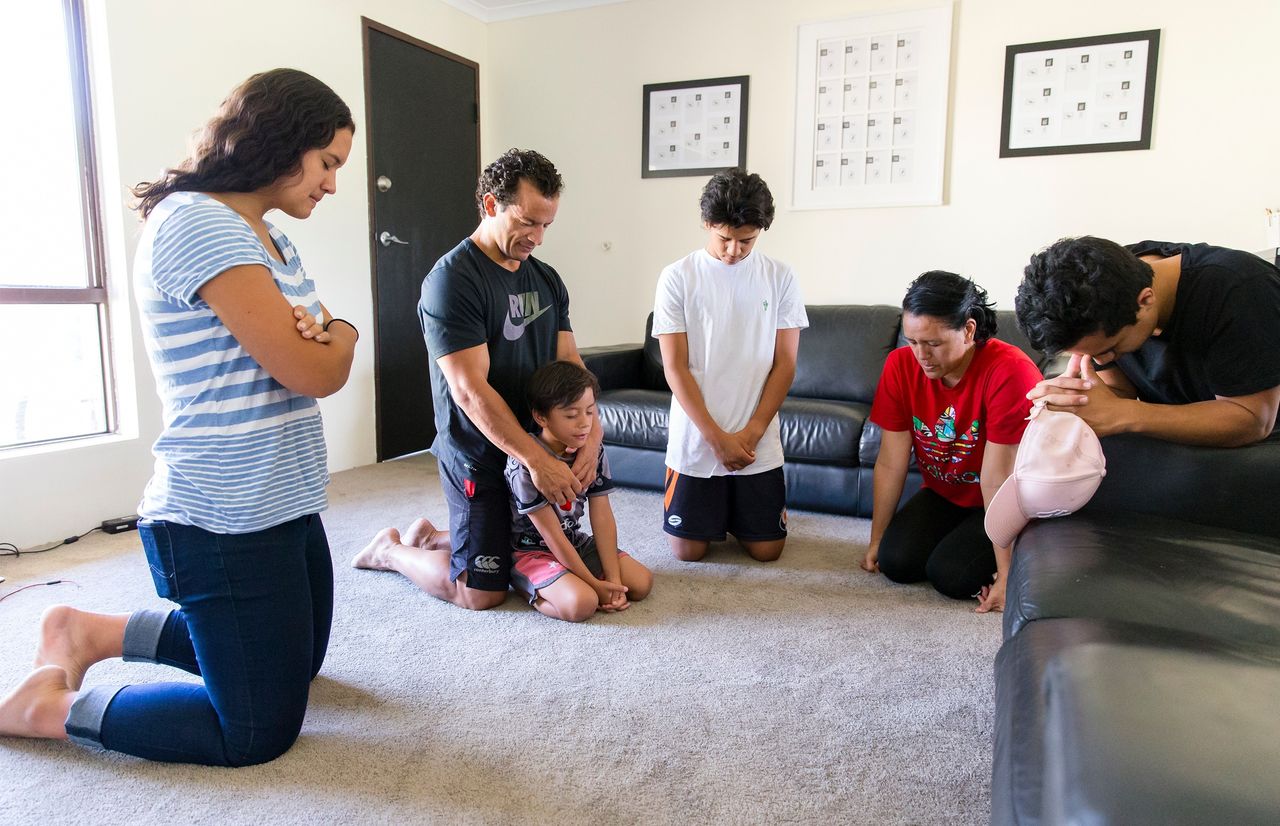 Familia orando juntos de rodillas
