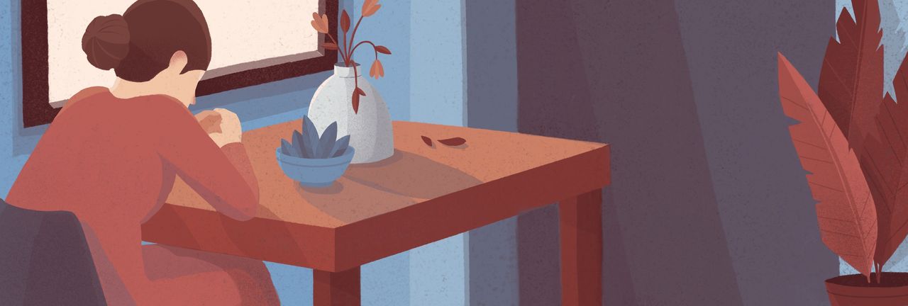 Una mujer está sentada en una silla, estudiando un libro