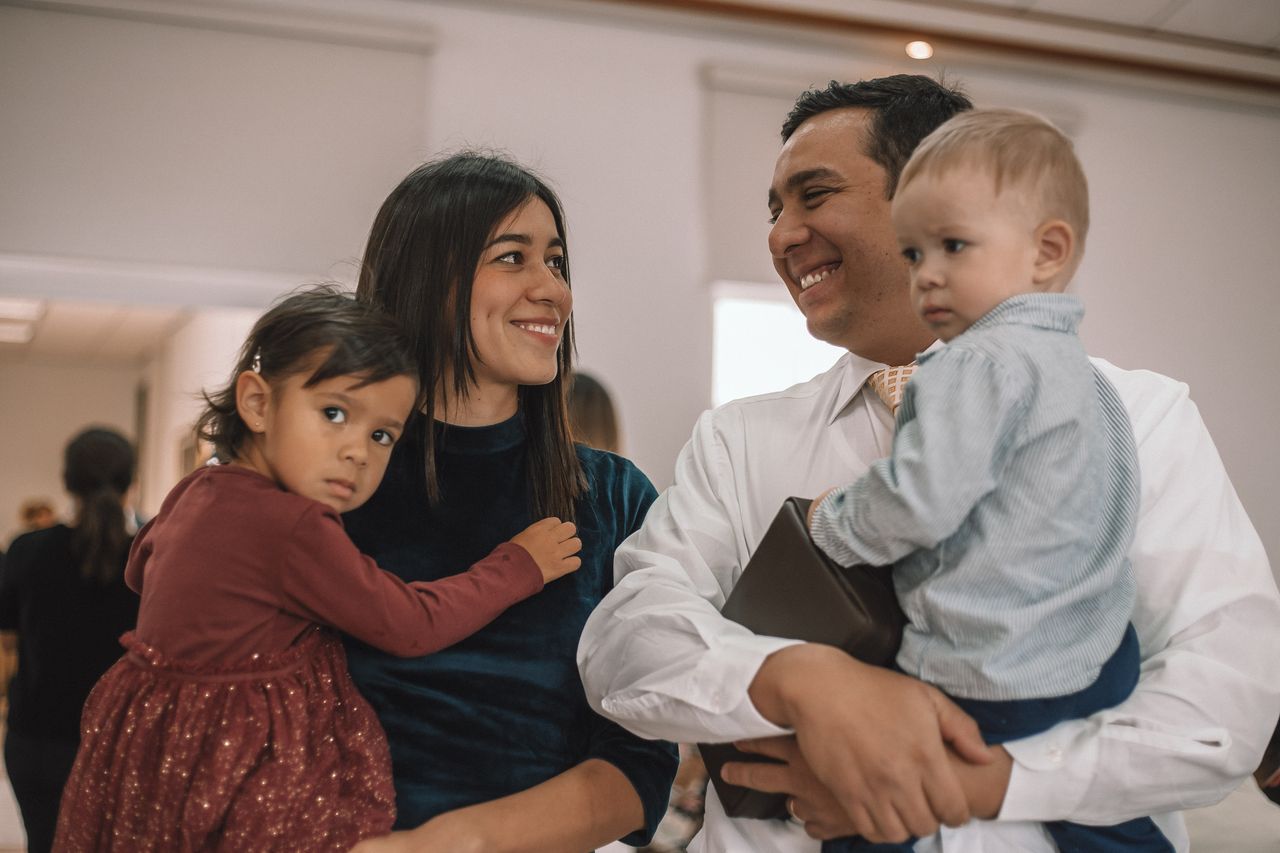 Una pareja casada se sonríe mientras llevan a sus hijos a la capilla