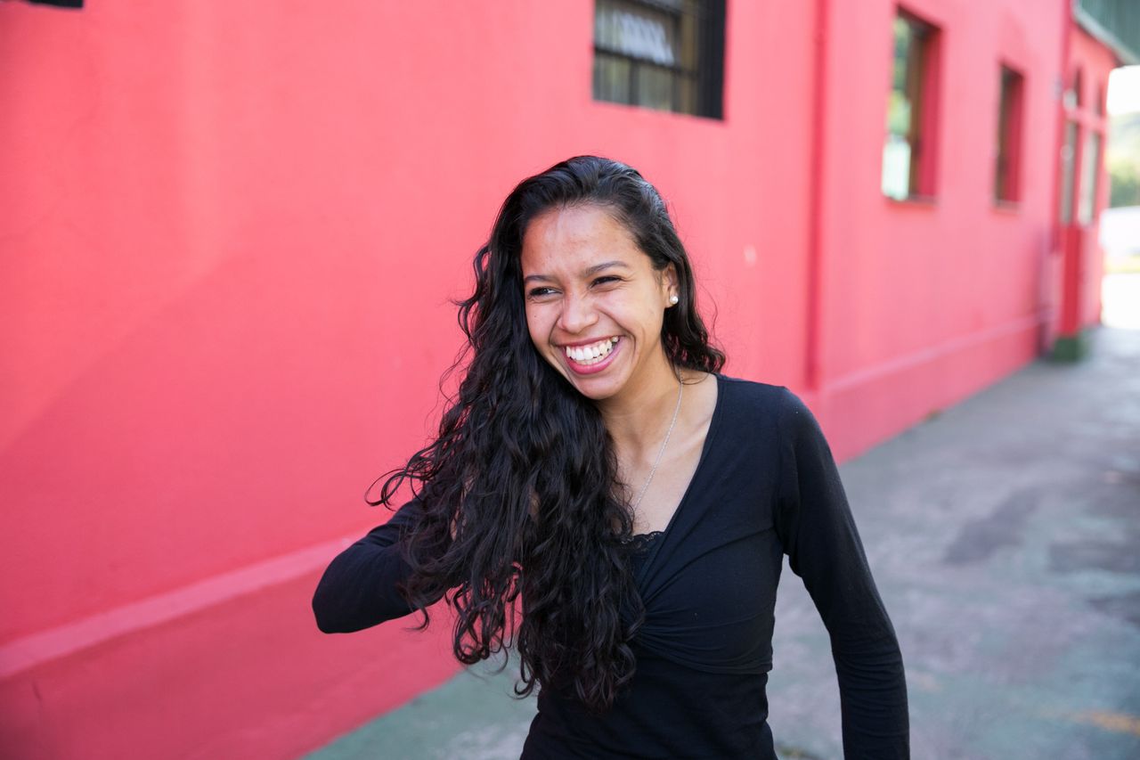 Una mujer sonríe al sentir el amor de Dios en su vida