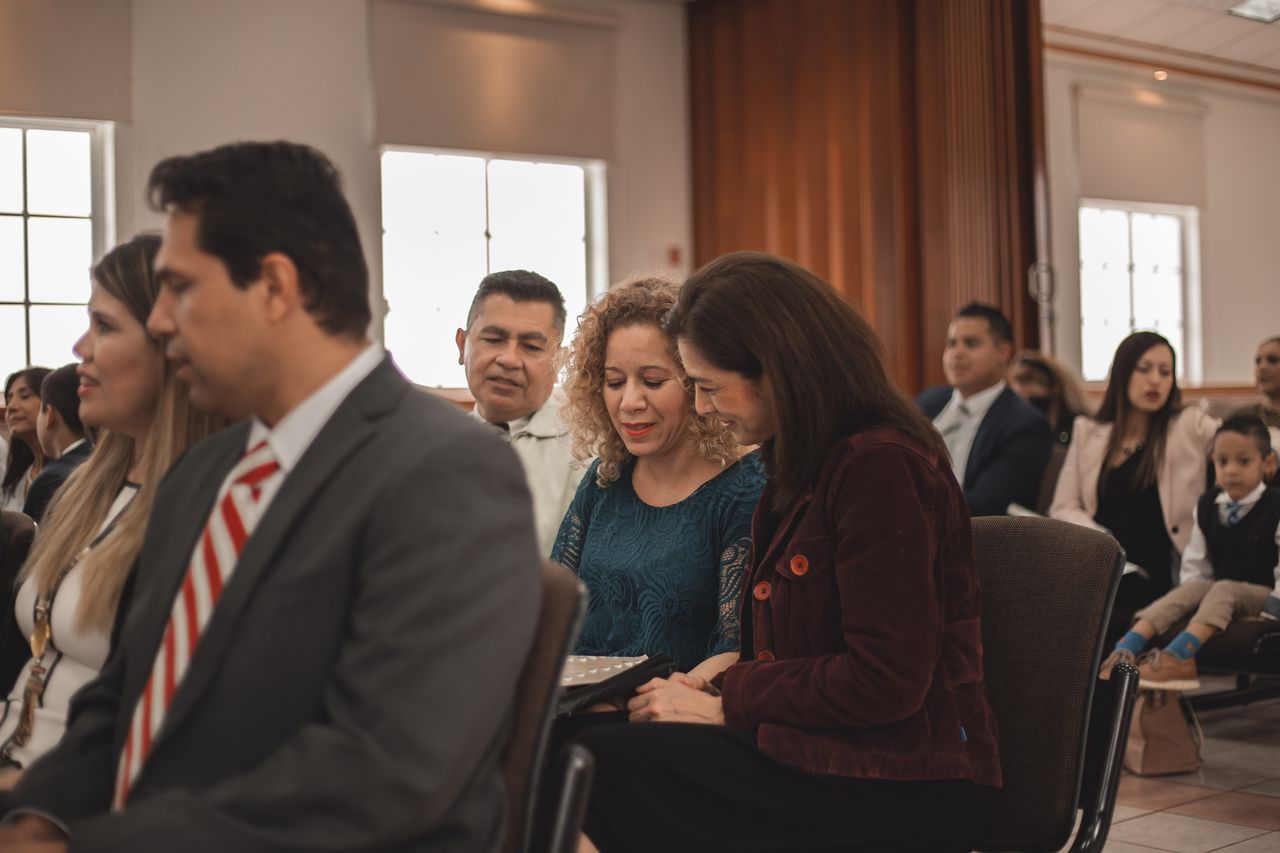 Personas participando en la reunión sacramental