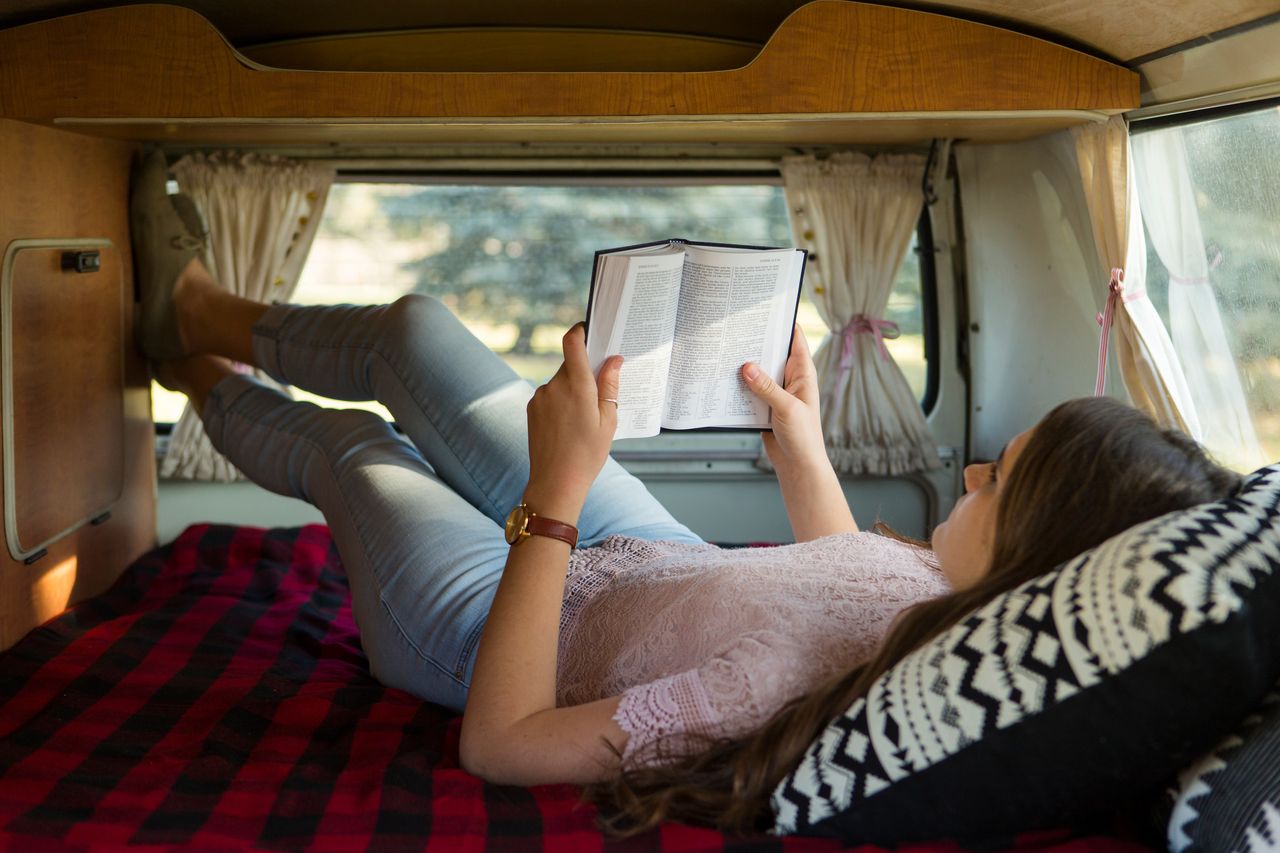 Una mujer lee la Biblia en su auto